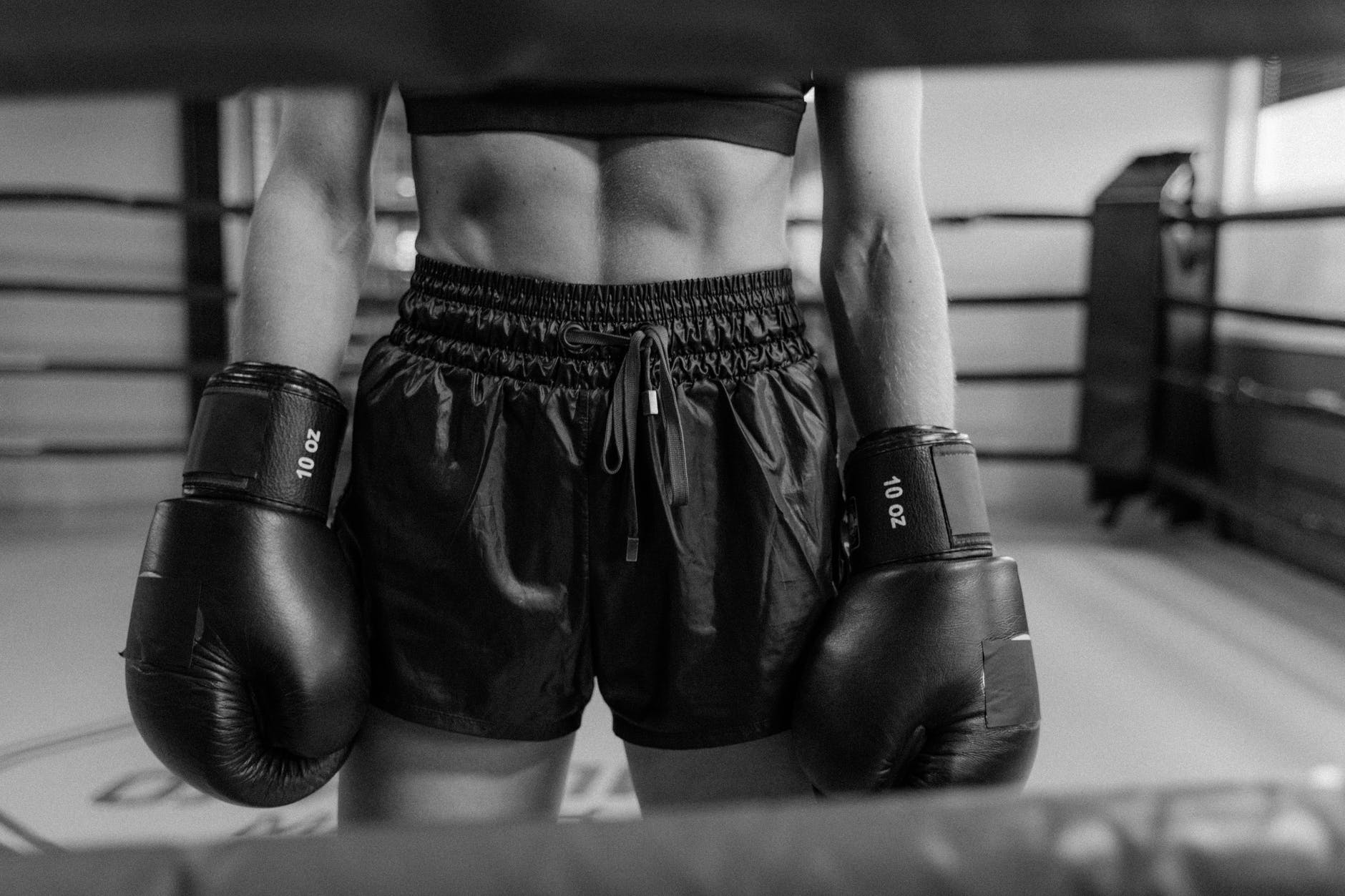 grayscale photo of woman in black boxing gloves