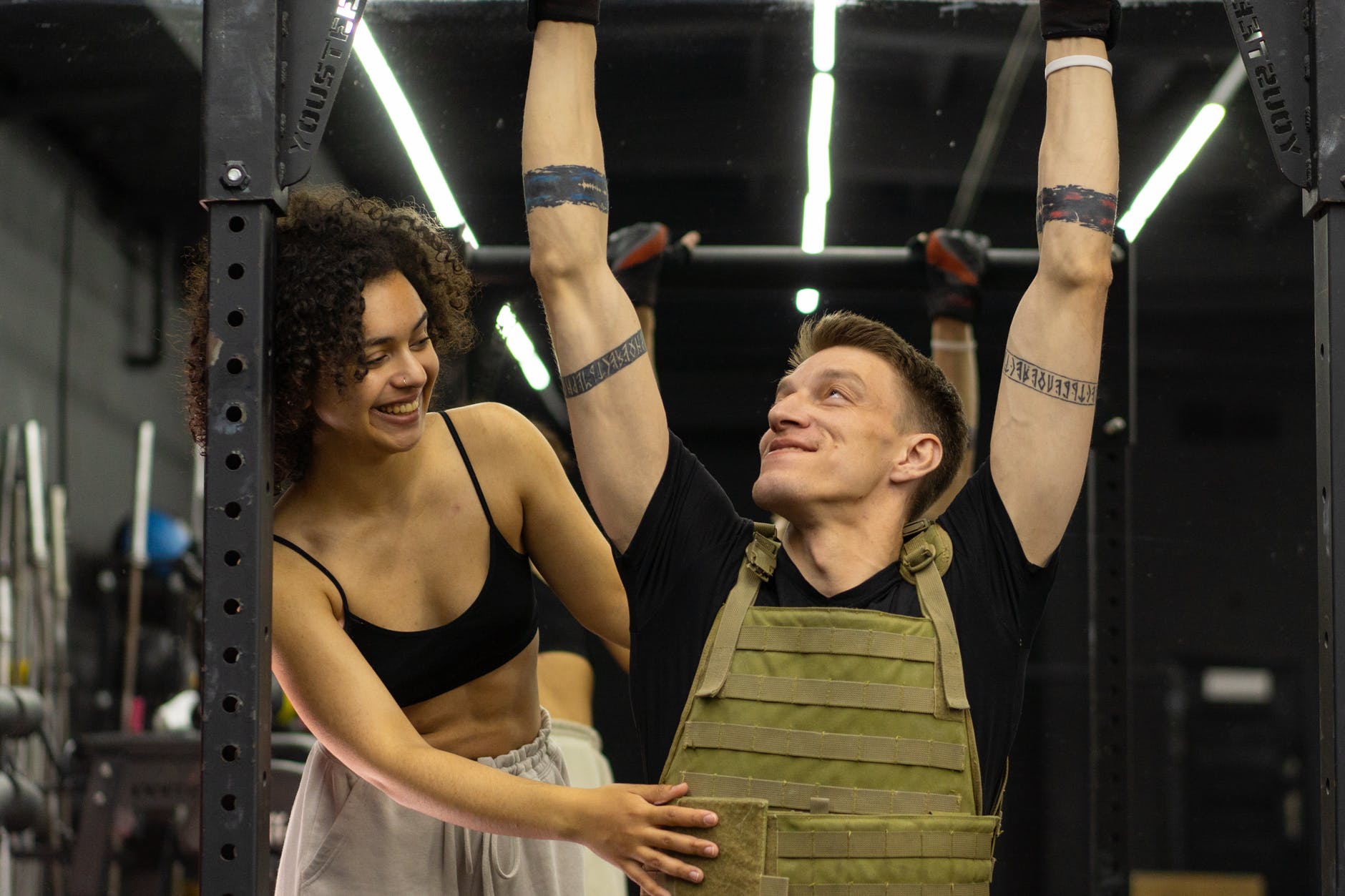 a woman helping her client do a pull up