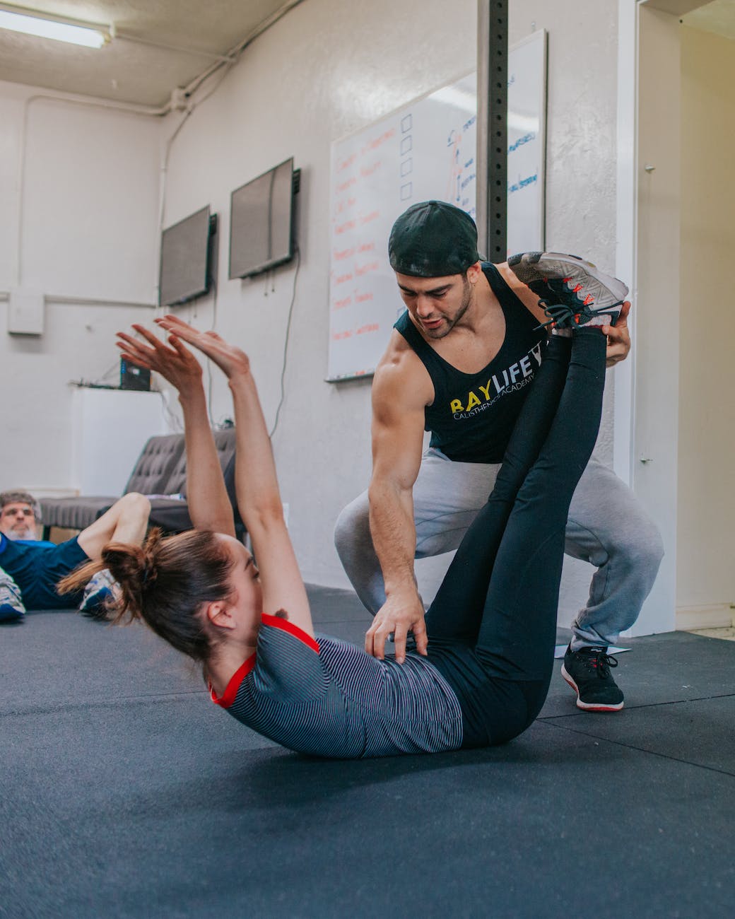 man touching woman on her belly while lying on floor